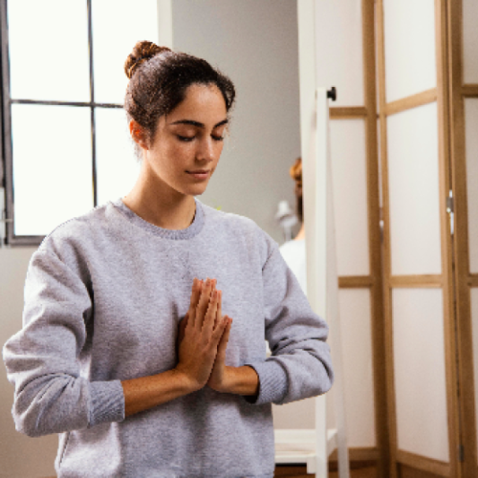 mujer meditando con sudadera